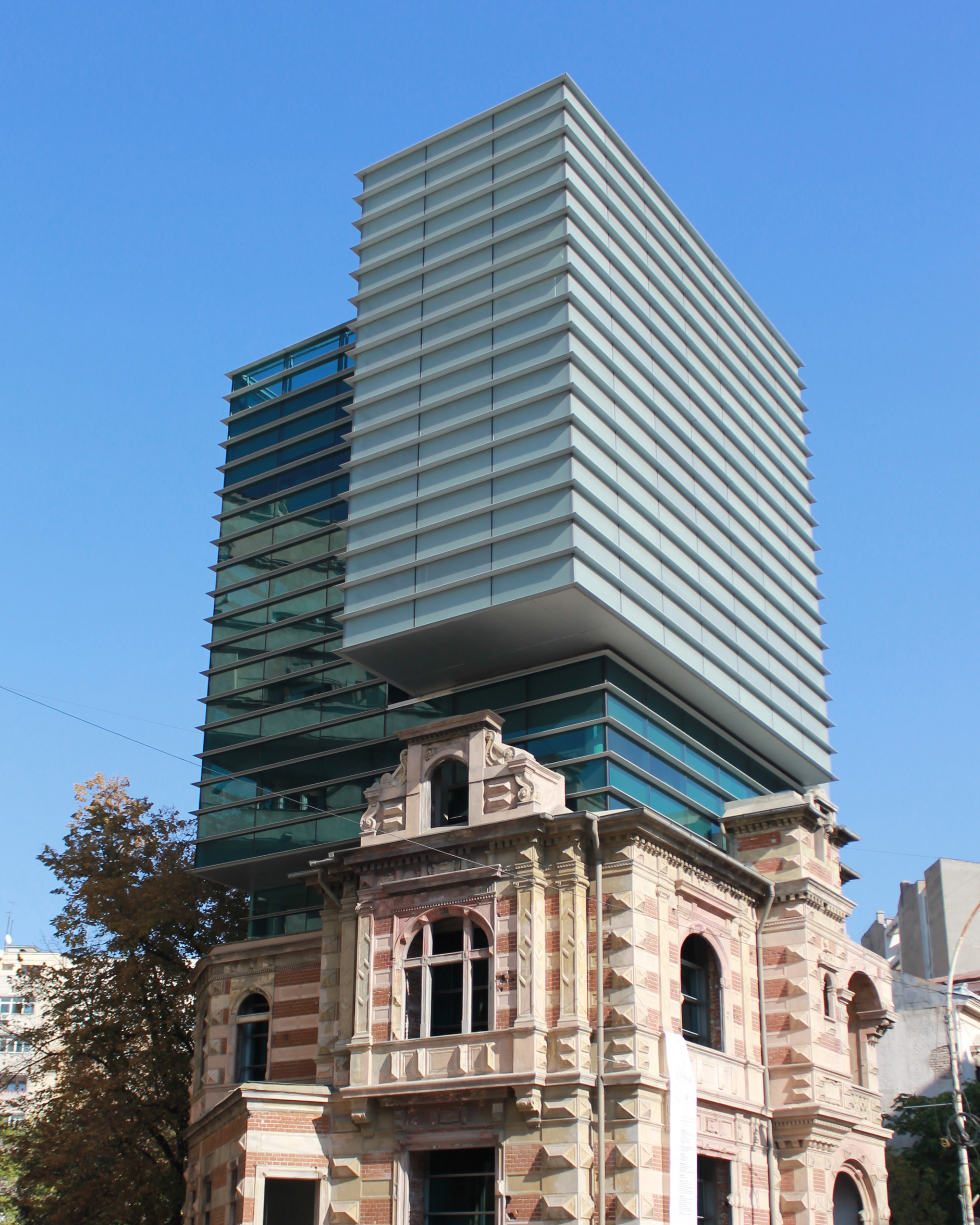 A historic Bucharest building set against a contemporary glass tower